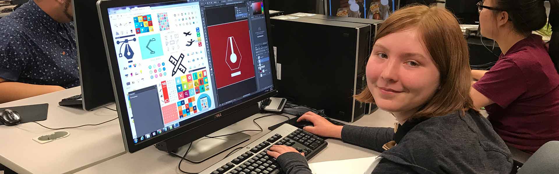 A student smiling at the camera, working on a site.