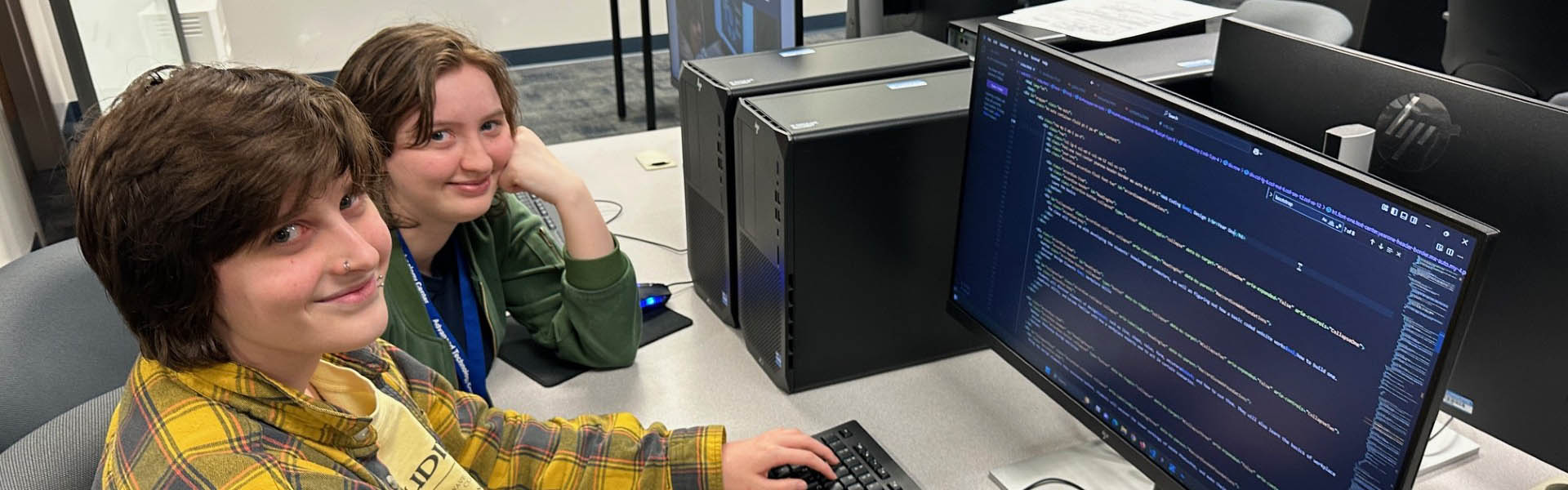 Two students smiling at the camera, working on this site.